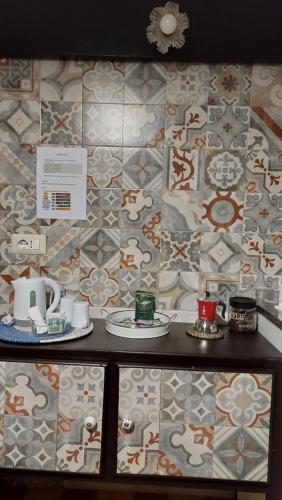 AgiraにあるCasa Don Raffaeleのタイル張りの壁に皿とカップが並ぶテーブル