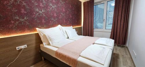 een slaapkamer met een bed met een rode muur bij DN Apartment W&W in Boedapest