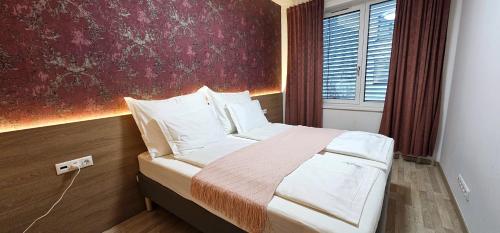 Un dormitorio con una cama con una pared roja. en DN Apartment W&W, en Budapest