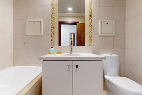 a bathroom with a sink and a tub and a toilet at West Heights 1 - Vacationer in Dubai