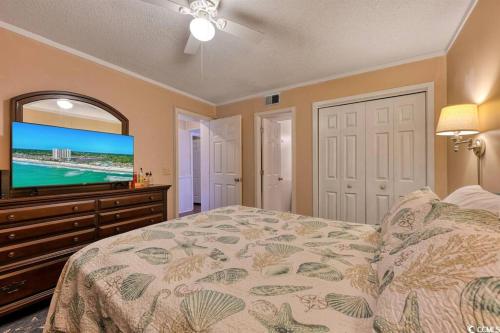 a bedroom with a bed and a flat screen tv at Family friendly, cozy, home at the beach in Myrtle Beach