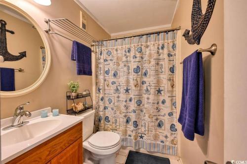 a bathroom with a toilet and a sink and a mirror at Family friendly, cozy, home at the beach in Myrtle Beach