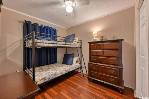 a bedroom with two bunk beds and a dresser at Family friendly, cozy, home at the beach in Myrtle Beach