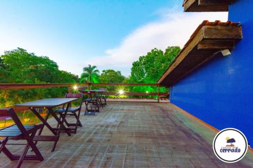 a patio with tables and chairs on a blue building at Pousada Cantos do Cerrado in Chapada dos Guimarães
