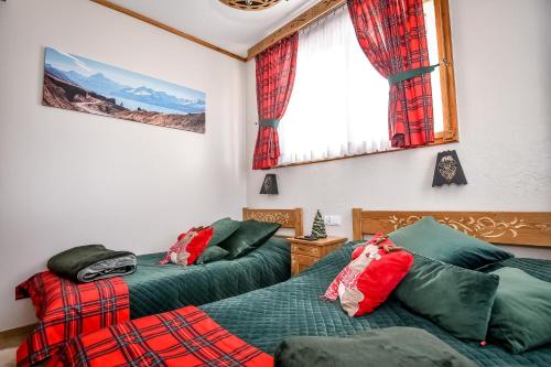 two beds in a room with red and green at Domek u Zosi in Zakopane