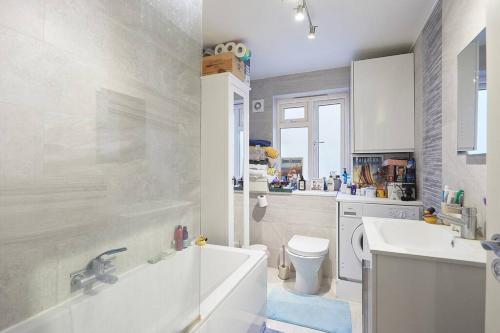 uma casa de banho com uma banheira, um lavatório e um WC. em A lovely and comfortable flat in South London em Thornton Heath