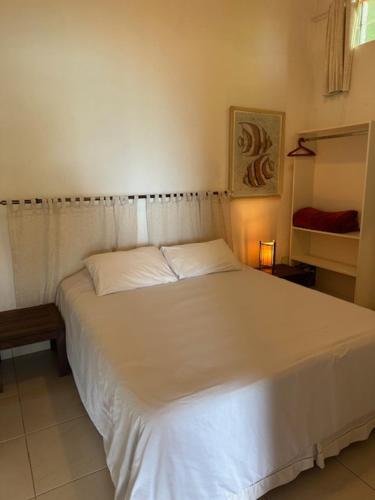 a bedroom with a white bed in a room at Casa com vista a praia da Barra do Sahy in Barra do Sahy