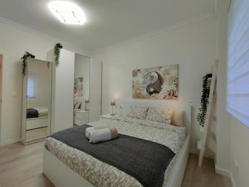 1 dormitorio blanco con 1 cama grande y espejo en Non Stress Turia en Valencia