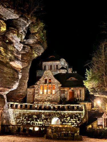 Una vieja casa de piedra se ilumina por la noche en Hřensko 27 Apartmány en Hřensko