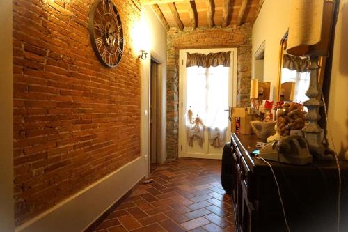 a room with a brick wall and a door at Villa Lucetta, Emily, pool, fantastic view, Lucca in Matraia