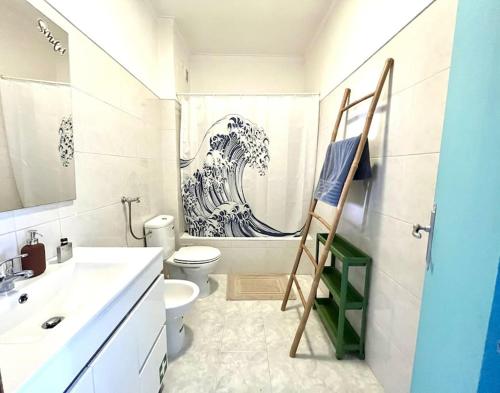a bathroom with a painting of a wave on the wall at CASA COSY - Caparica Beach and Surf Apartment in Costa da Caparica