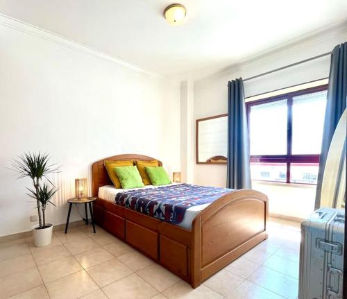sypialnia z łóżkiem z zielonymi poduszkami w obiekcie CASA COSY - Caparica Beach and Surf Apartment w Costa de Caparica