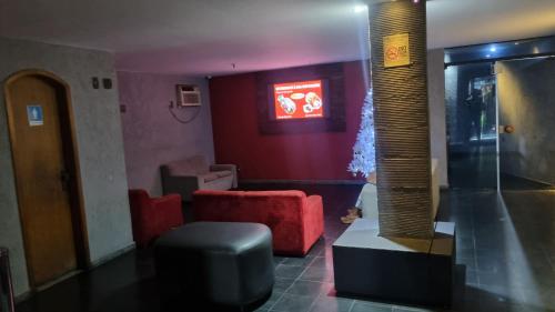 a living room with a red couch and a red chair at STOP TIME HOTE in Rio de Janeiro