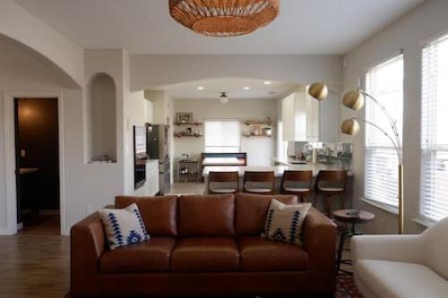 a living room with a brown couch and a kitchen at Remodeled Large home w yard Gated PRIME location in Albuquerque