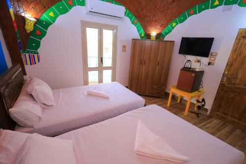 a bedroom with two beds and a arched ceiling at Nubian Popeye - Roof top - Nile View in Aswan