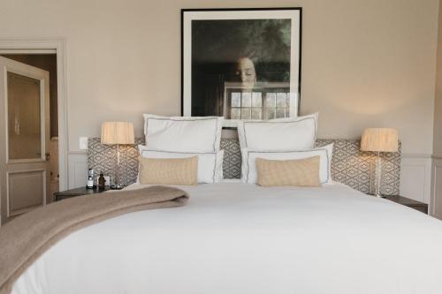 a bedroom with a large white bed with pillows at Erinvale Estate Hotel & Spa in Somerset West
