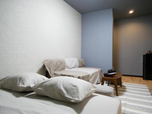 two beds with white pillows in a room at HOOD - Vacation STAY 46025v in Amami