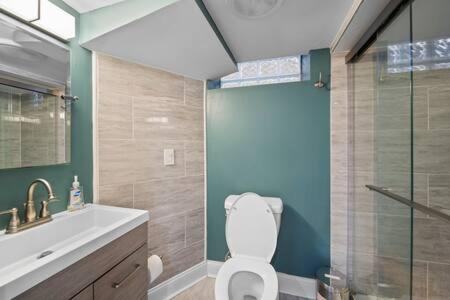 a bathroom with a toilet and a sink and a shower at Stylish Luxury 3bd home in Downtown Birmingham in Birmingham