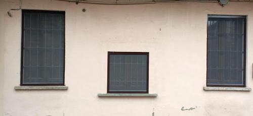 3 fenêtres sur le côté d'un bâtiment blanc dans l'établissement Super relax - Fiera Milano Rho, à Canegrate
