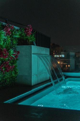 a water fountain on the side of a building at Athesense Suites in Athens
