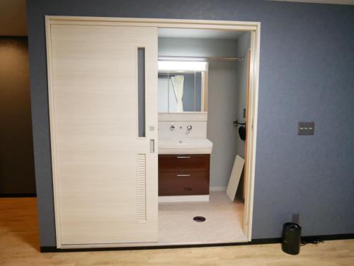 La salle de bains est pourvue d'un lavabo et d'un miroir. dans l'établissement HOOD - Vacation STAY 35938v, à Amami