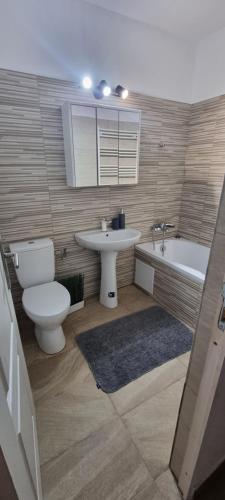 ein Badezimmer mit einem WC, einem Waschbecken und einer Badewanne in der Unterkunft Cozy Home Deva in Deva