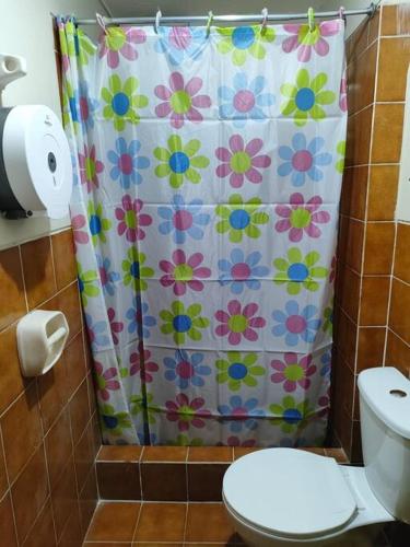 a bathroom with a shower curtain with a toilet at Departamento 4 camas 3 hab in Tacna