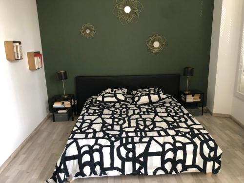 une chambre avec un lit avec une couette noire et blanche dans l'établissement Maison avec jardin et piscine, à Marseille