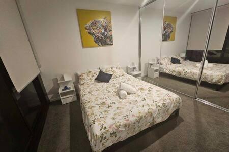 a bedroom with two beds and a mirror at Tucked Away on the Tenth Floor at Woden in Phillip