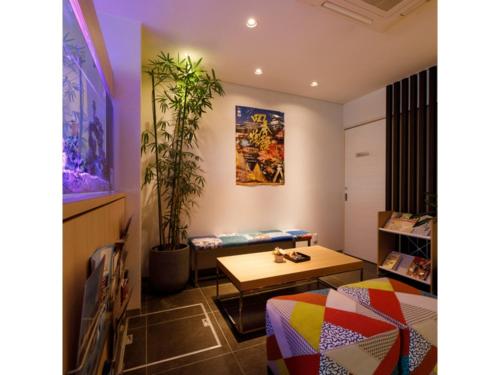 um quarto com uma mesa e um banco e uma planta em Kanazawa Station Hotel - Vacation STAY 36365v em Kanazawa