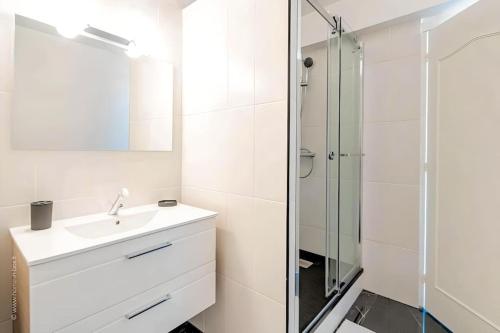 een witte badkamer met een wastafel en een douche bij Le Malt - Centre ville - Orly - Proche Gare - Elégant à la française in Juvisy-sur-Orge