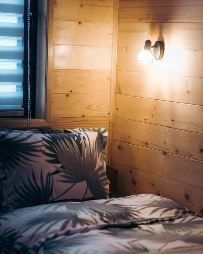 a bedroom with a bed with a wooden wall at Vila Helena -Apartman 2 in Nova Varoš