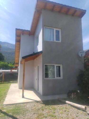 una gran casa blanca con una puerta delante de ella en Departamentos Mate de Luna en El Bolsón