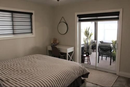 Schlafzimmer mit einem Bett, einem Schreibtisch und einem Fenster in der Unterkunft Lakeshore Bliss Retreat in Wheatley