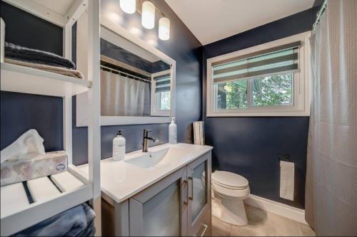 a bathroom with a sink and a toilet and a window at Lakeshore Bliss Retreat in Wheatley