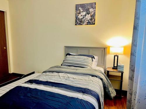 a bedroom with a bed with a blue and white comforter at Quiet Cozy 2BR APT Black out Curtains in Peoria