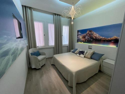 ラ・スペツィアにあるCinque terre Portovenereのベッドルーム1室(ベッド1台、椅子、絵画付)