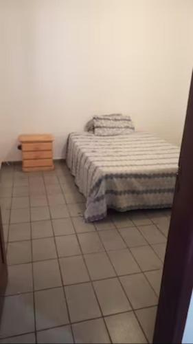 um quarto com uma cama e piso em azulejo em Quarto Disponível em Sobrado em São Paulo