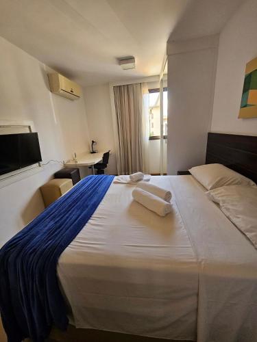 a hotel room with a large bed with towels on it at L207 Apartamento em resort à beira lago in Brasília