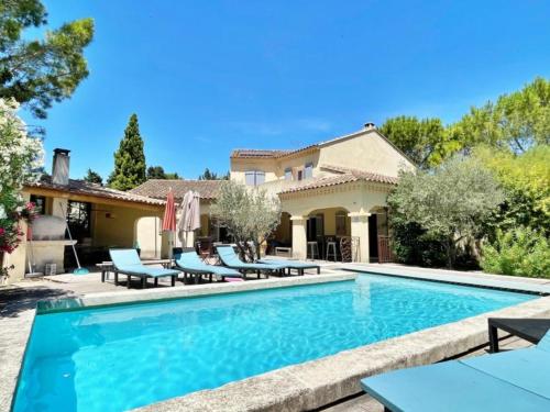 une piscine avec des chaises et une maison dans l'établissement Villa Althen, à Althen-des-Paluds