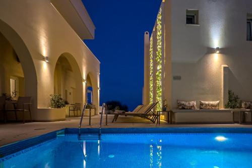 a swimming pool in a villa at night at Reverie Santorini Hotel in Firostefani