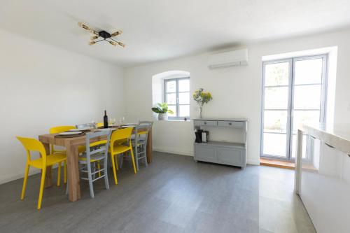a kitchen and dining room with a table and yellow chairs at Villa Floresco in Nerezine