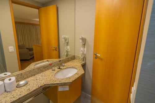 baño con lavabo y espejo grande en Flat Executive Transamerica Faria Lima Itaim en São Paulo