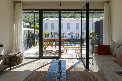 een woonkamer met een bank en uitzicht op een patio bij Vie Ventoux in Malaucène