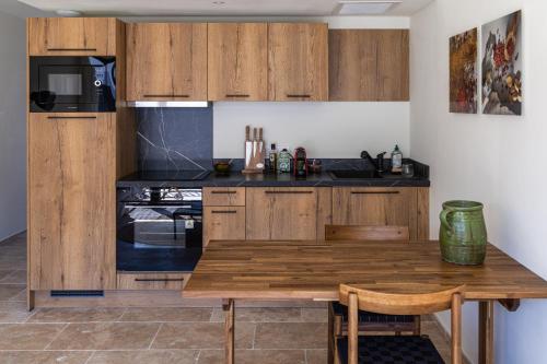 eine Küche mit Holzschränken und einem Holztisch in der Unterkunft Vie Ventoux - Studio in Malaucène
