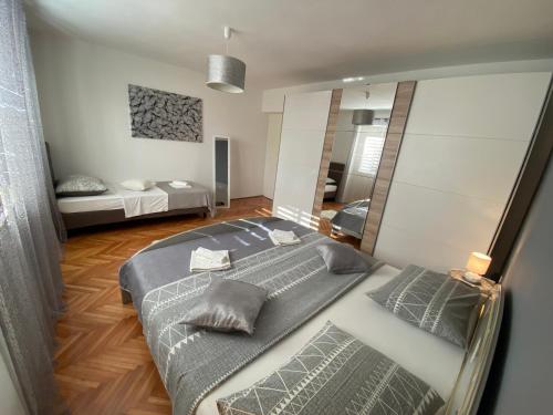 a bedroom with a large bed and a mirror at Apartment Darija with private pool in Kaštela