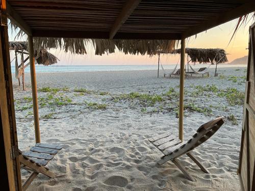 two chairs and an umbrella on a beach at Casa Gitana in Chamuscadero