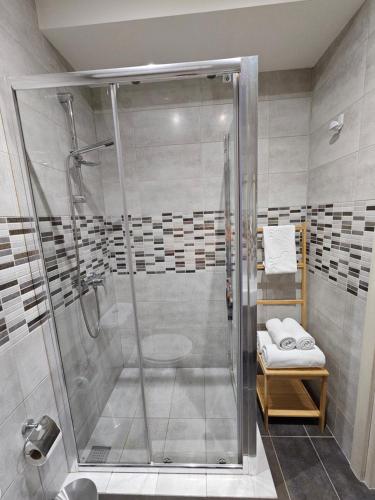 a shower with a glass door in a bathroom at KORZO SUITES SLIEMA I in Sliema
