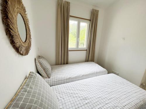 a bedroom with two beds and a mirror on the wall at Maisonnette avec 2 chambres climatisée en face de la plage de Gigaro in La Croix-Valmer
