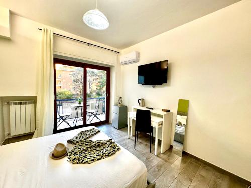 ソレントにあるcenter SUITE sorrento baby 2のベッドとテレビ付きの机のある部屋